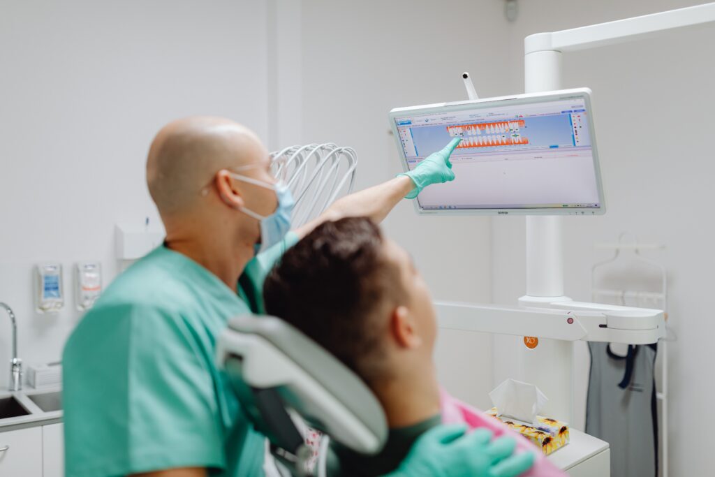 Dentist reviewing digital dental images with a patient during a routine examination.
